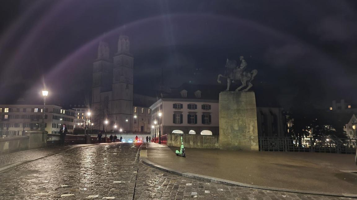 Im Vordergrund sieht man im Halbdunkel die Reiterstatutre von Hans Waldmann, Teile der Münsterbrücke sowie das unbeleuchtete  Grossmünster. 