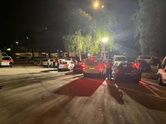Fahrzeuge auf einem Parkplatz bei Nacht während einer Polizeikontrolle