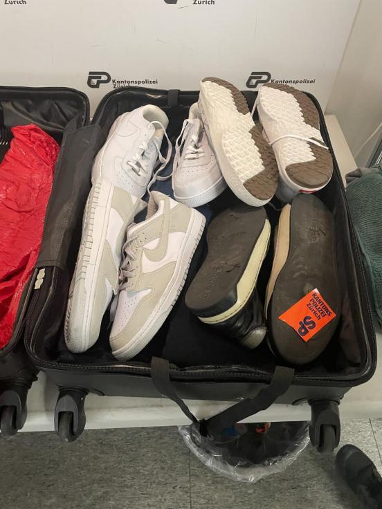 ein Koffer mit vier Paar Schuhen