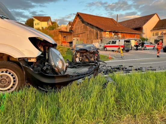 zwei Unfallfahrzeuge auf einer Strasse. Im Hintergrund  Polizeifahrzeuge