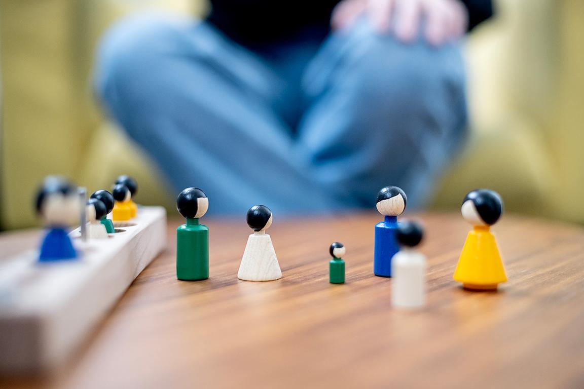 Kleine Spielfiguren auf einem Tisch als Tools für Psychotherapie.