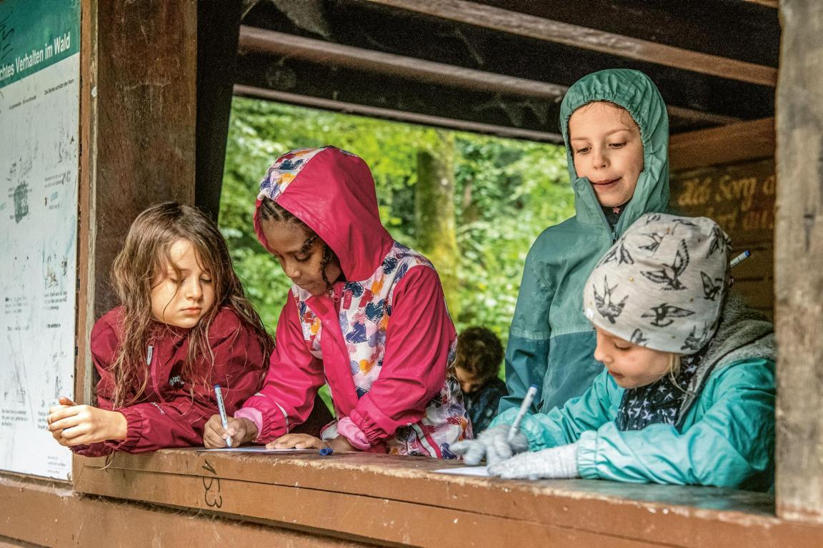 Schülerinnen lösen Matheaufgaben in der Waldhütte