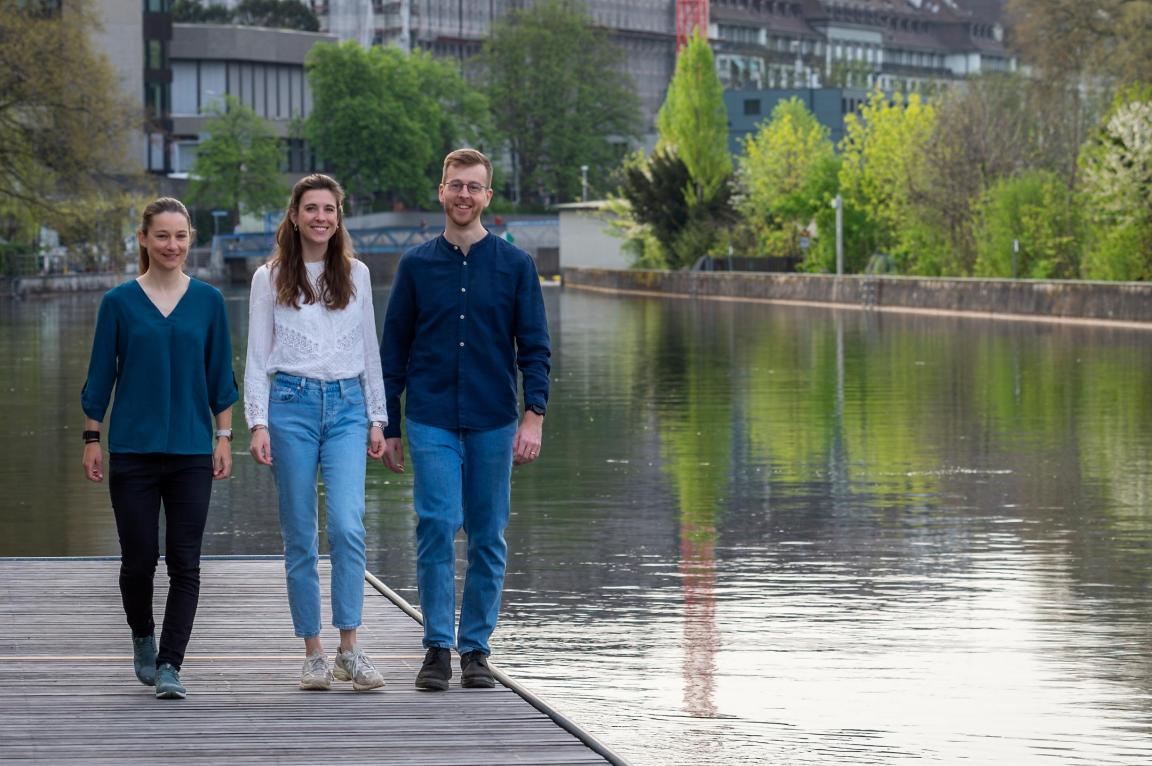 Projektteam von #hallowasser: Lea Fuchs, Lisa Heidler und Matthias Wick auf einem Steg am Wasser.