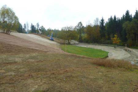 Gebiet mit Bagger und Lastwagen mit neu eingebauten Materialien.