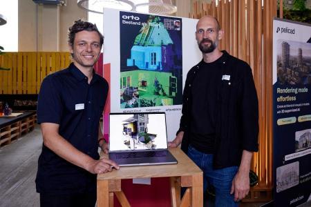 Alexander Werle und Felix Matschinske, beide Mitgründer von orto, stehen nebeneinander an ihrem Stand uind lächeln in die Kamera.