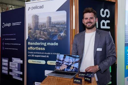 Yannic Schwarz, Mitgründer von Pelicad, steht vor seinem Stand und lächelt in die Kamera.  Auf dem Roll-up im Hintergrund steht auf English: «Rendering made effortless - Create architectural visuals in minutes with 3D supervised AI»-