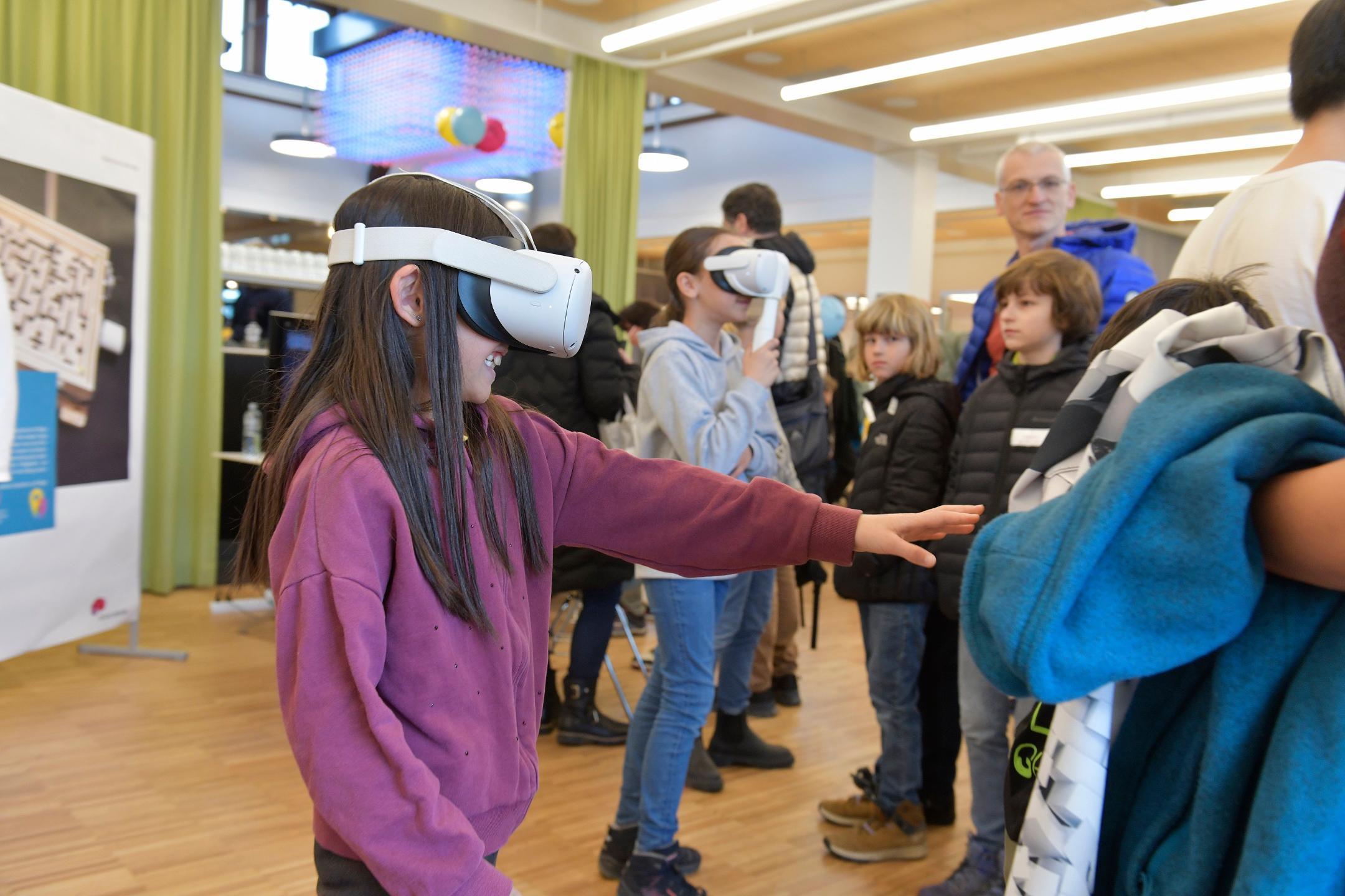 Ein Mädchen mit einer Virtual-Reality-Brille streckt seinen Arm aus, um etwas zu ertasten
