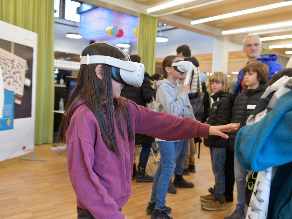 Ein Mädchen mit einer Virtual-Reality-Brille streckt seinen Arm aus, um etwas zu ertasten